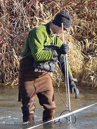 Andy Ray measures current velocity used to determine river discharge. 